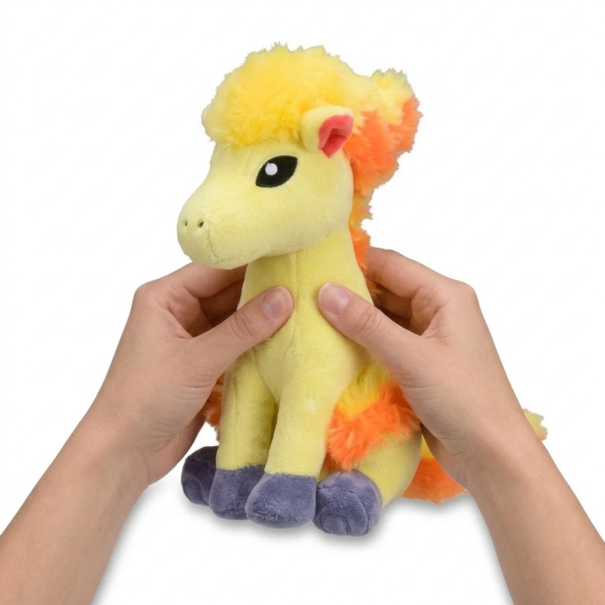 Ponyta Peluche sostenida en las manos