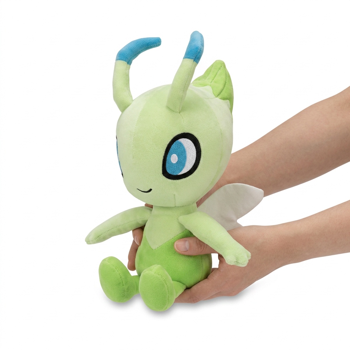 Celebi Peluche sostenido en las manos