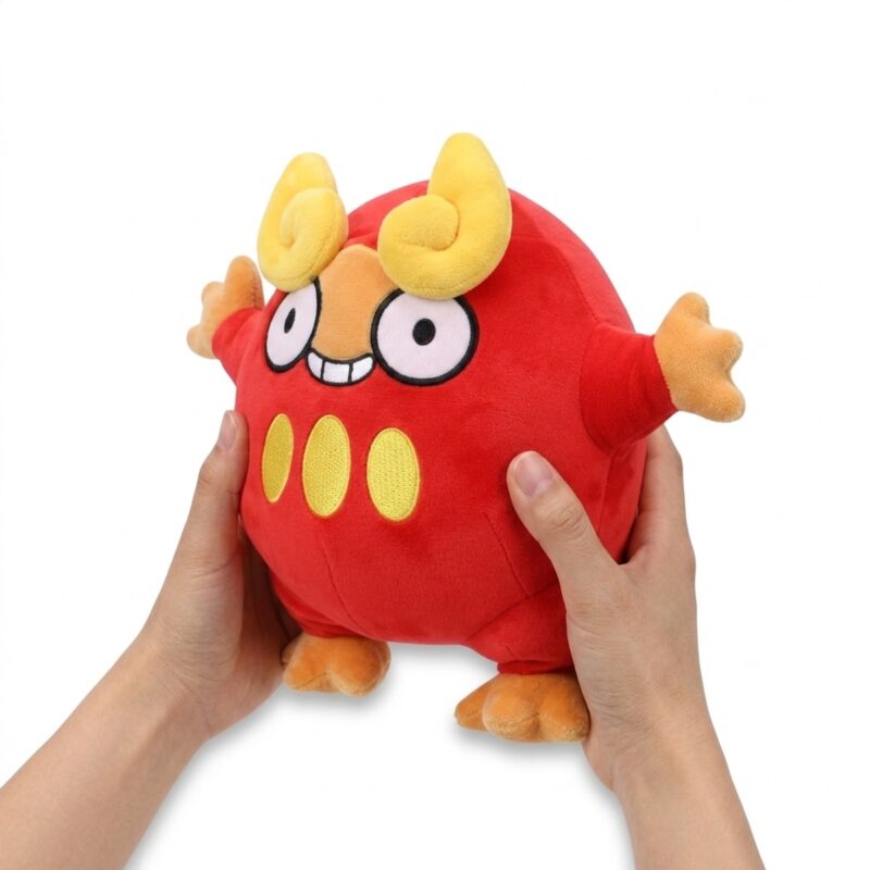 Darumaka Peluche sostenida en las manos