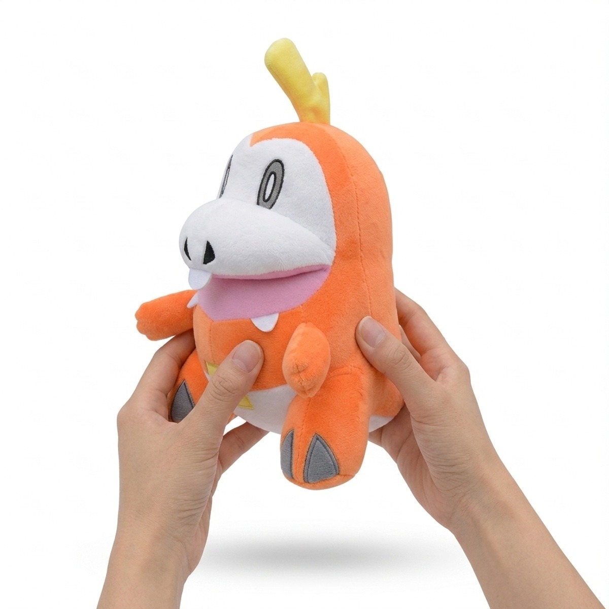 Fuecoco Peluche sostenido en las manos