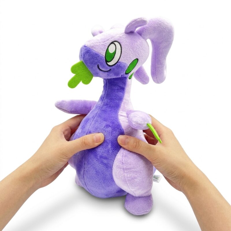 Goodra Peluche sostenido en las manos