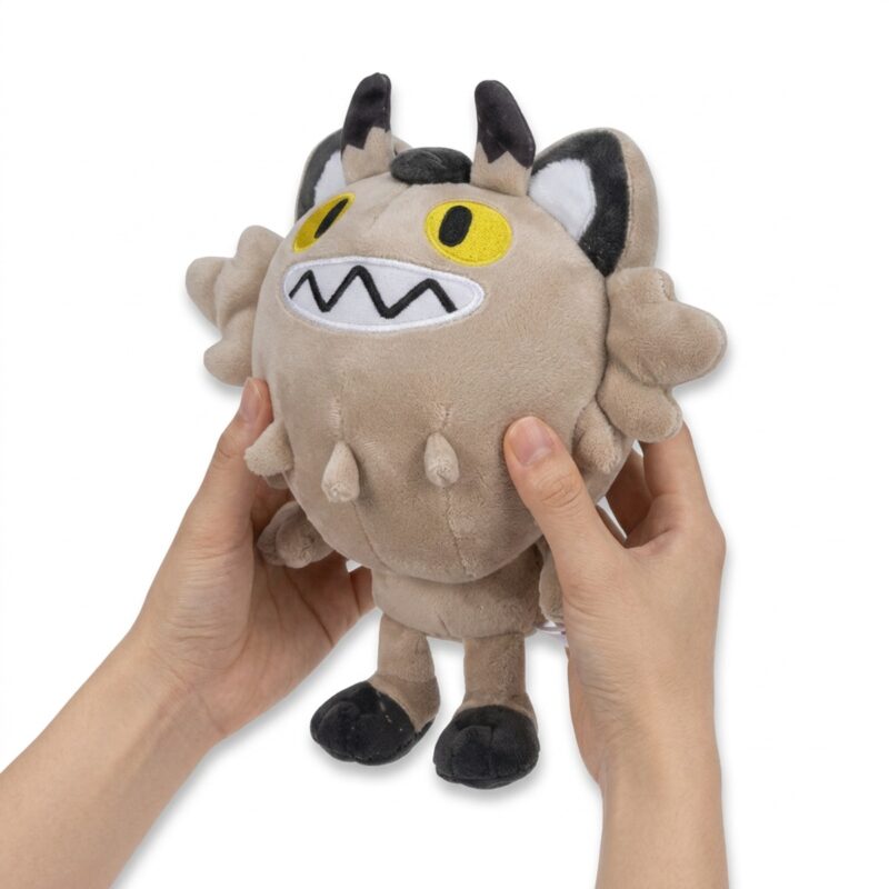 Peluche Meowth de Galar sostenido en las manos